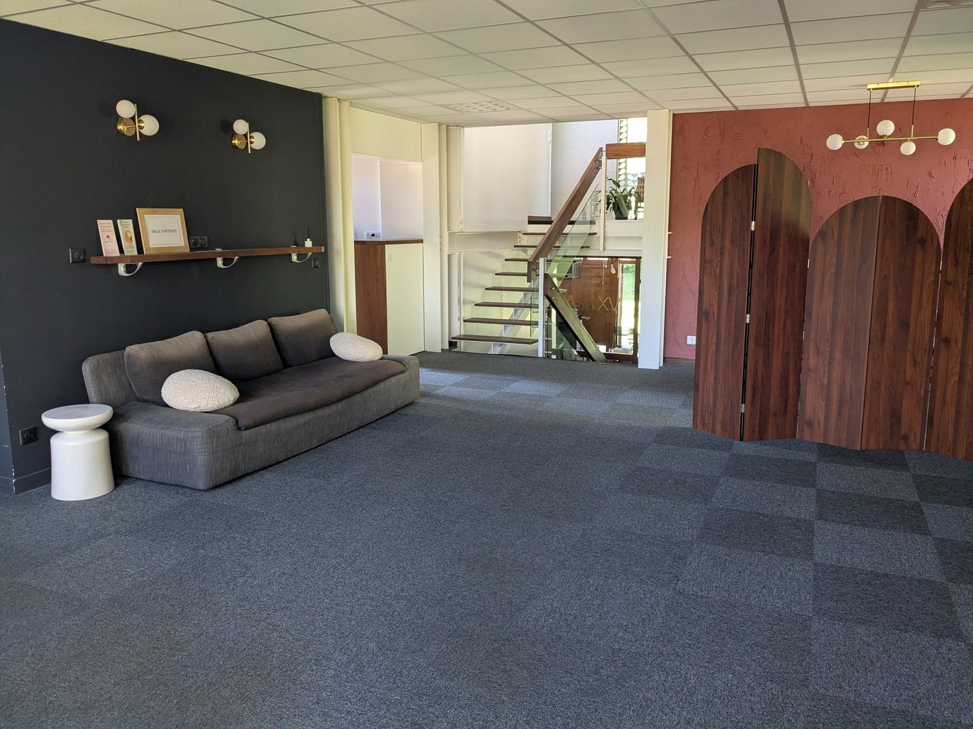 Le hall d'accueil du 30 chemin de la Planquette, avec son canapé et ses paravents en bois cintré